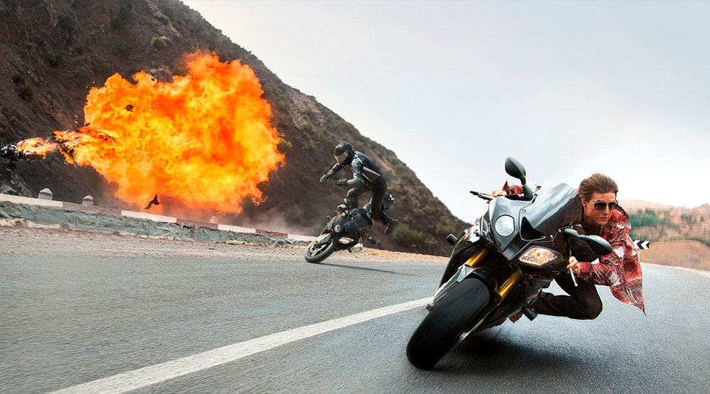 Tom Cruise on a motorbike runs away from bad boys on explosion background msmstudy.eu